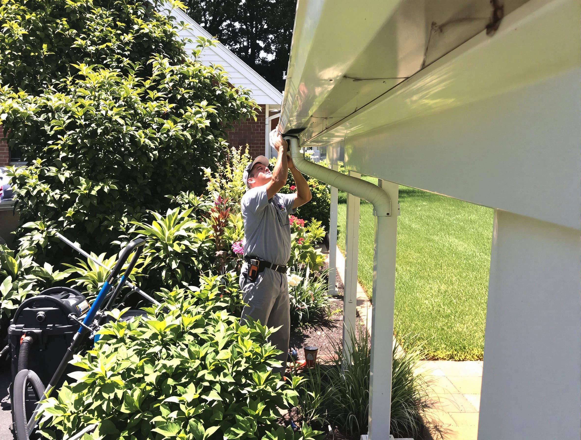 Technician flushing a blockage from a downspout in Parma, OH